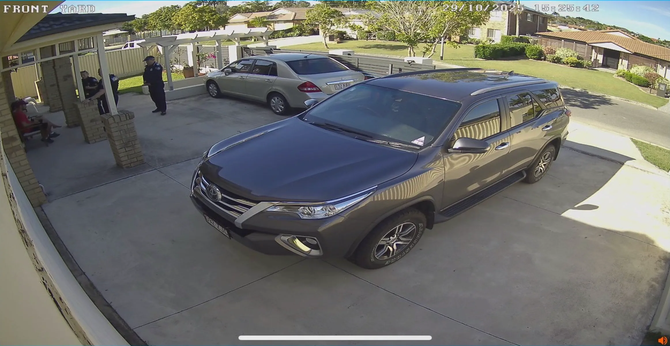 Front yard CCTV 15:00:33 — officer on the porch, 29 October 2025